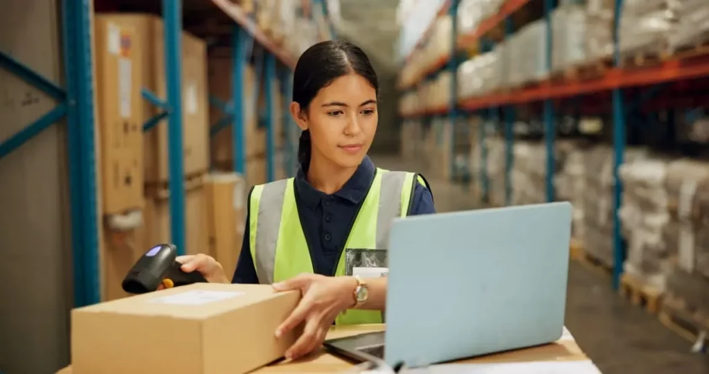 mujer haciendo inventario en almacén utilizando software en ordenador