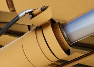 Primer plano de un cilindro hidráulico industrial con manguera de presión instalado en equipo de manipulación de cargas