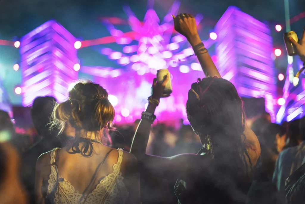personas disfrutando de un evento en vivo con música y luces en un ambiente de entretenimiento nocturno