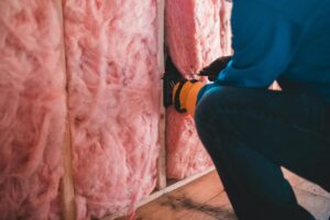 Instalación de aislamiento térmico con paneles de lana mineral en una pared durante una obra de reforma.