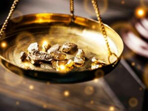 Lingotes y fragmentos de oro sobre una balanza dorada, simbolizando la producción y el comercio mundial de oro